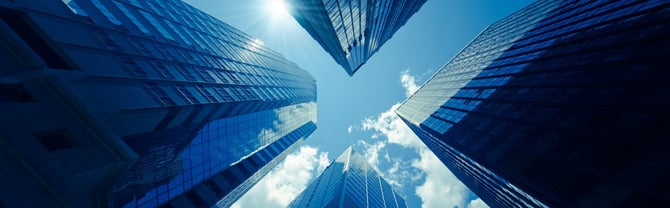 City sky view obstructed by high-rise buildings and providing reflective surfaces for multi-path GNSS signals.